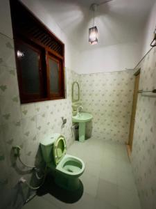 a bathroom with a green toilet and a sink at Twice Happy Beach Garden in Tangalle