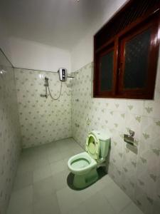 a bathroom with a green toilet and a window at Twice Happy Beach Garden in Tangalle
