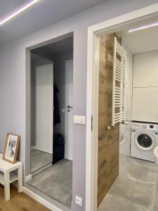 ein Badezimmer mit einem Spiegel und einer Waschmaschine in der Unterkunft Enes Apartments Legnicka Street A in Breslau