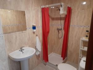 y baño con lavabo y ducha con cortina de ducha roja. en Apartmento Sostoa 2, en Málaga