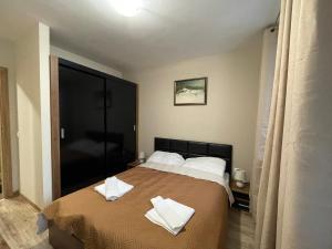 a bedroom with a bed with two towels on it at Apartment E23 Borovets Gardens in Borovets