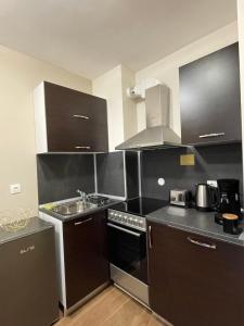- une cuisine avec des placards noirs et blancs et un évier dans l'établissement Apartment E23 Borovets Gardens, à Borovets