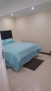 ein Schlafzimmer mit einem Bett mit einer blauen Bettdecke in der Unterkunft 24 Outeniqua Bluff Outeniqua Strand Glentana x 3 Units in Outeniqua Strand + 23 Fotos