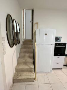 un escalier avec un réfrigérateur blanc dans la cuisine dans l'établissement Beach front! 2 bedrooms right on the boardwalk, à Tel Aviv