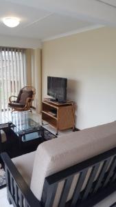 ein Wohnzimmer mit einem Bett und einem Fernseher in der Unterkunft 24 Outeniqua Bluff Outeniqua Strand Glentana x 3 Units in Outeniqua Strand