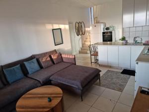 ein Wohnzimmer mit einem Sofa und einer Küche in der Unterkunft Beach front! 2 bedrooms right on the boardwalk in Tel Aviv