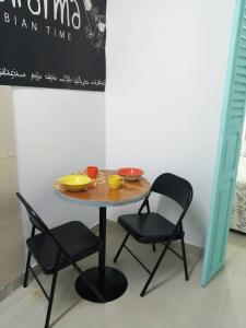 een tafel met twee stoelen en een tafel met kommen erop bij APARTAESTUDIO EN MANGA CARTAGENA in Cartagena