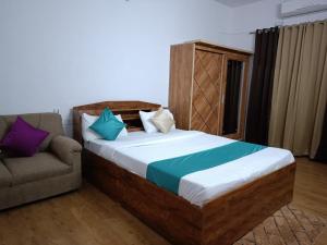 a bedroom with a large bed and a couch at Happy Stay Near Airport Pune in Pune