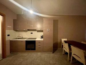 a kitchen with a table and a sink and a light at Central Sauze-GestingHome in Sauze dʼOulx