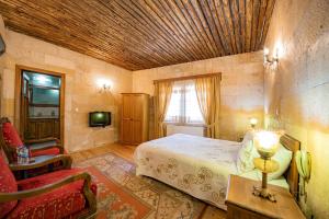 a bedroom with a bed and a chair in a room at Upper Greek House in Mustafapaşa