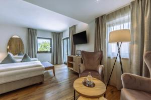 a living room with a bed and a couch at Hotel Ansitz Rungghof in Appiano sulla Strada del Vino