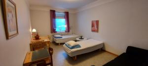 ピーテオにあるPiteå Vandrarhemのベッド2台と窓が備わる小さな客室です。