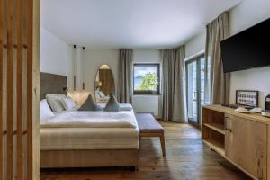 a bedroom with a bed and a large window at Hotel Ansitz Rungghof in Appiano sulla Strada del Vino