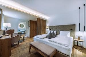 a bedroom with a large white bed and a desk at Hotel Ansitz Rungghof in Appiano sulla Strada del Vino