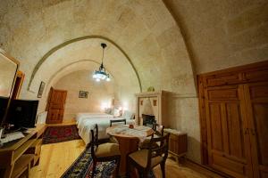 a bedroom with a bed and a table and chairs at Upper Greek House in Mustafapaşa