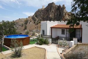 a house with a swimming pool in front of a mountain at Casa Rincon a detached two bed cottage in Lubrín