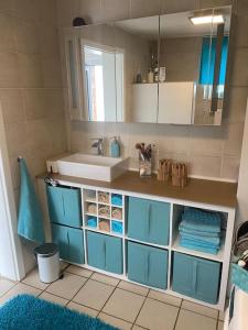 La salle de bains est pourvue d'un lavabo et d'une armoire bleue. dans l'établissement Kinofeeling im Reihenhaus mit schönem Garten, à Schwarzenfeld