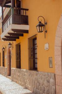 Villa Vicuña Wine & Boutique Hotel في كفايات: مبنى أصفر مع أضواء شوارع وجدار