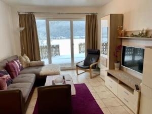 a living room with a couch and a television at Almlodge Flachau in Flachau