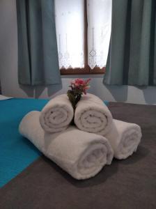 einen Haufen Handtücher und Blumen auf dem Bett in der Unterkunft Kadmilos suites Samothraki in Samothráki