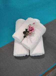 a white towel with a pink flower on it at Kadmilos suites Samothraki in Samothraki