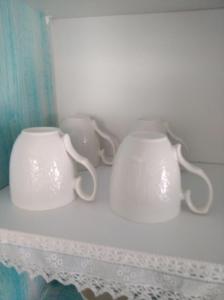 two white mugs are sitting on a shelf at Kadmilos suites Samothraki in Samothráki