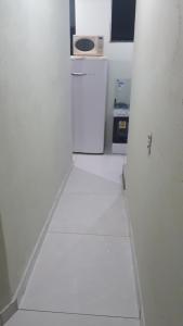 a white room with a refrigerator and a microwave at Porto apartamento in Porto Seguro