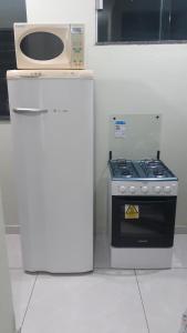a kitchen with a stove and a microwave at Porto apartamento in Porto Seguro