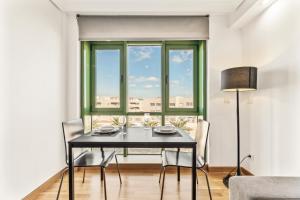 una sala da pranzo con tavolo, sedie e finestra di Home2Book Stylish Apartment Arrecife Beach ad Arrecife