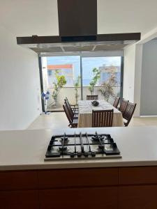 a kitchen with a stove top in a kitchen with a table at Kriol Guest House in Praia