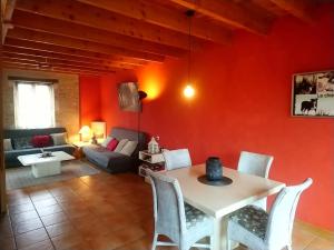 uma sala de estar com paredes vermelhas e uma mesa e cadeiras em Clan Boucheron em Louroux-Bourbonnais