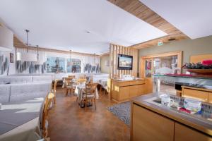 - une cuisine et une salle à manger avec une table et des chaises dans l'établissement Hotel Garni Entstrasser, à Kitzbühel