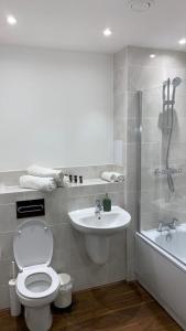 y baño con aseo, lavabo y ducha. en Brand New One Bed Luxury Flat No Parties No Events, en West Thurrock