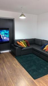 a living room with a couch and a flat screen tv at Brand New One Bed Luxury Flat No Parties No Events in West Thurrock