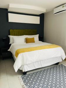 1 dormitorio con 1 cama grande con manta amarilla en Mo'Acress Lifestyle, 