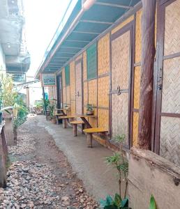 a row of wooden benches on a building at Coron Backpacker Guesthouse in Coron