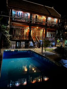 un edificio con piscina por la noche en NamKhan Riverside en Luang Prabang