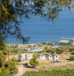 eine Gruppe von Häusern auf einem Hügel in der Nähe des Wassers in der Unterkunft Alikon Adult-Only in Neos Marmaras