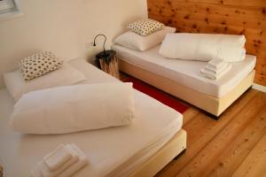 two beds in a room with wooden floors at Serpentin Apartment in Turracher Hohe