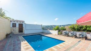une piscine avec deux chaises à côté d'une maison dans l'établissement Casa El Cerro El Borge by Ruralidays, à Borge