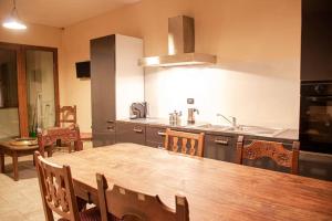 a kitchen with a wooden table and a dining room at Grand Sauze Apartment-GestingHome in Sauze dʼOulx