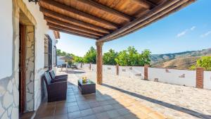 une terrasse avec un canapé et une table dans l'établissement Casa El Cerro El Borge by Ruralidays, à Borge