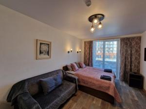 1 dormitorio con cama, sofá y ventana en New Gudauri, Apartment 244, en Gudauri