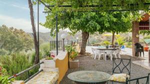 a patio with a table and chairs and trees at Alojamiento Rural El Salto Villafranca de Córdoba by Ruralidays in Córdoba
