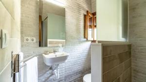 une salle de bain blanche avec un lavabo et un miroir dans l'établissement Cortijo El Prado Villanueva de Algaidas by Ruralidays, à Villanueva de Algaidas 17 autres photos