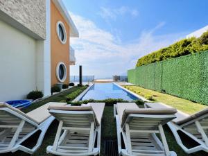 un patio trasero con sillas y una piscina en Villa with Private Pool and Terrace in Alanya en İshaklı