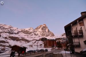 a snow covered mountain in the background of a city at Breuil Cervinia Funicular House with Private Garage in Breuil-Cervinia