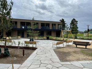 un edificio con panchine di fronte a un parco giochi di Hotell Fritidsparken a Skien