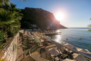 a beach with a bunch of umbrellas and the ocean at Hotel Mavi Deniz in Turunç