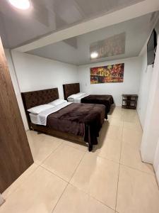 een slaapkamer met 2 bedden in een kamer bij Amarena Hotel Boutique in Manizales